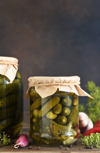 В стеклянную банку аккуратно укладываются огурцы вместе с укропом и чесноком