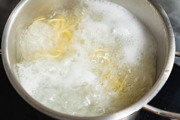 Лапша для рамена варится в кипящей воде в большой кастрюле