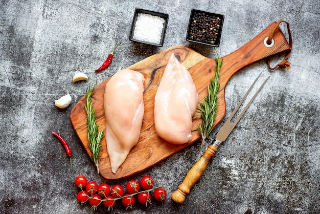 Нарезанная курица и лук на разделочной доске, специи рядом