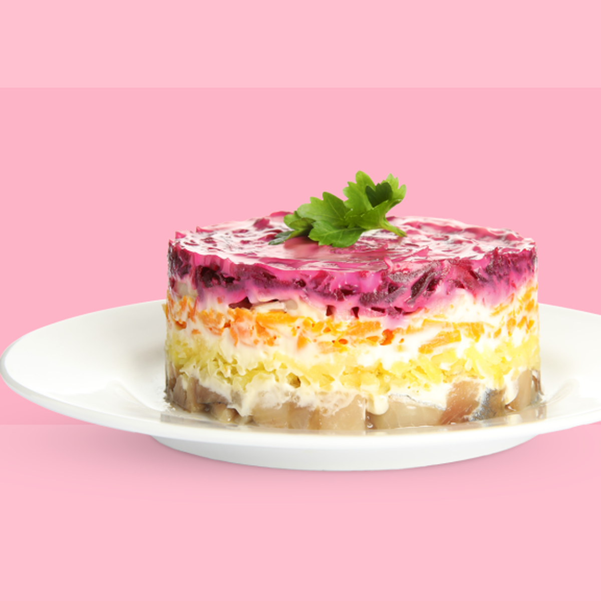 Готовый салат 'Селёдка под шубой' с яркими слоями, украшенный зеленью