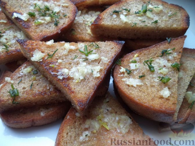 Кусочки хлеба с чесноком жарятся до золотистой корочки