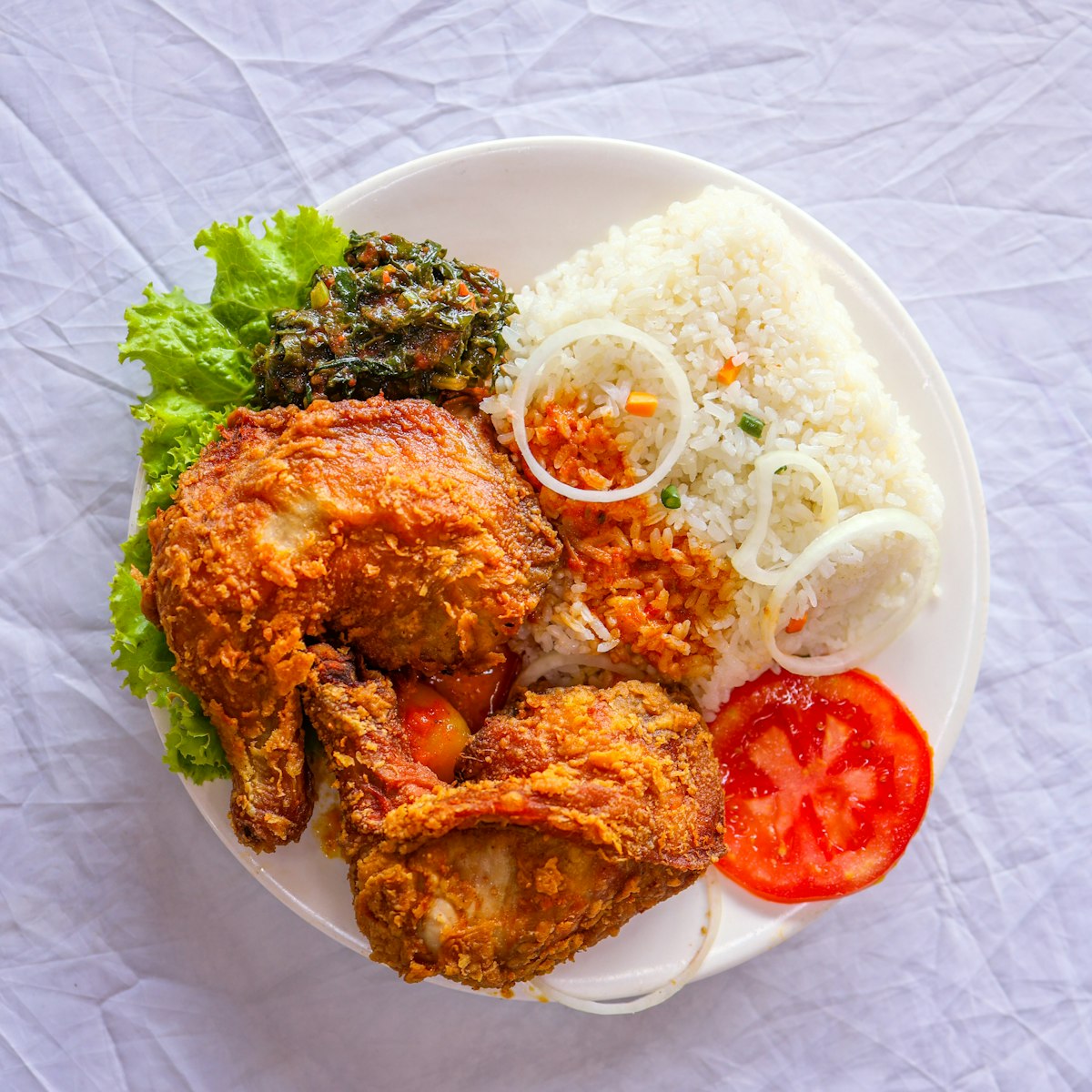 Сочные куриные бёдра тандури с хрустящей корочкой и рисом басмати на тарелке